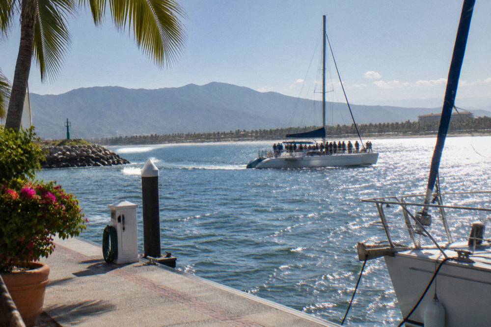 Whale watching catamaran under bright midday sun near the mouth of Banderas Bay