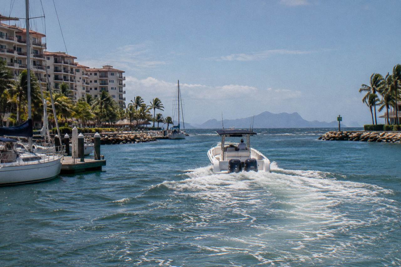 Speedboat crossing open water toward rocky uninhabited islands on the horizon