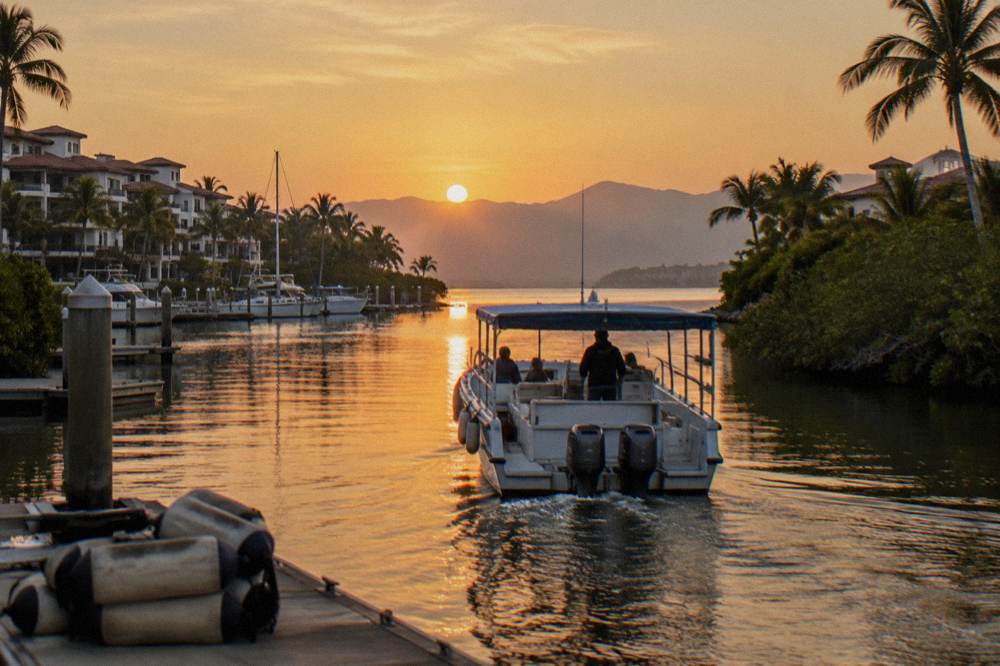 Small whale watching boat leaving a marina at sunrise in calm dry season conditions