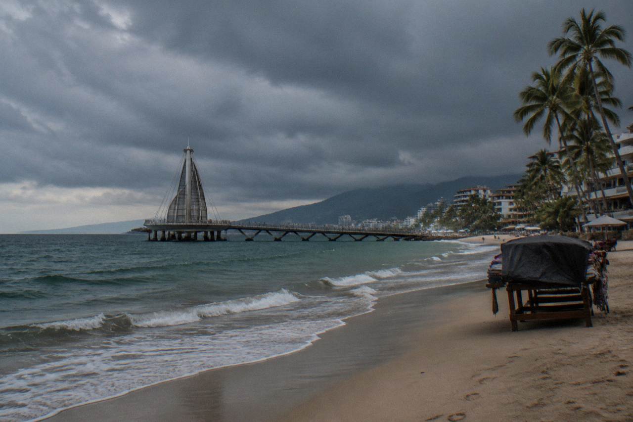 Rain clouds over Banderas Bay with dark water and an empty shoreline