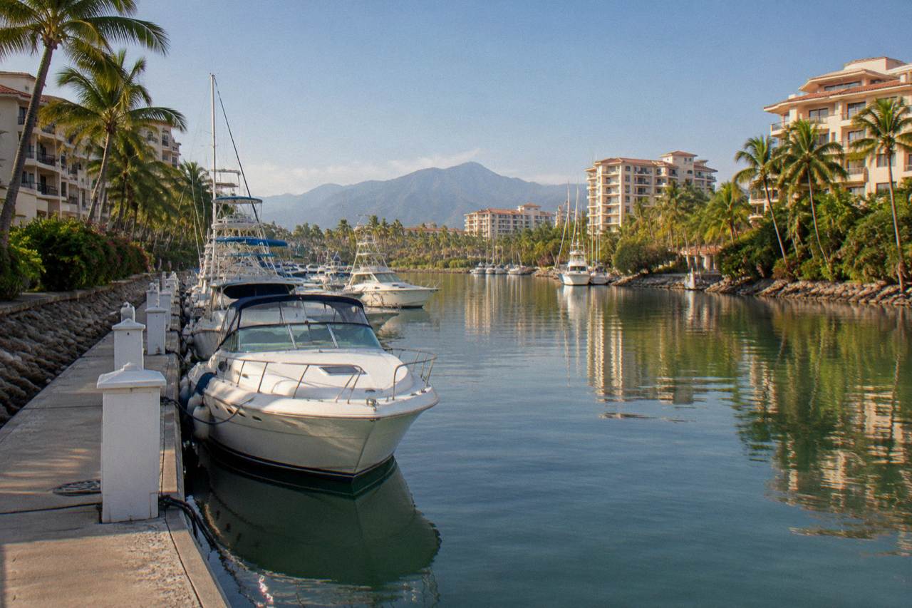 Boats moored in a marina on Banderas Bay with hills behind at morning