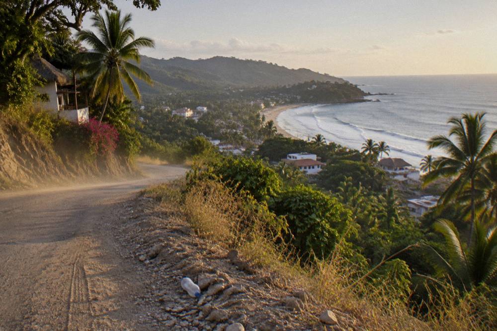 Coastal road winding along green hills above the Pacific