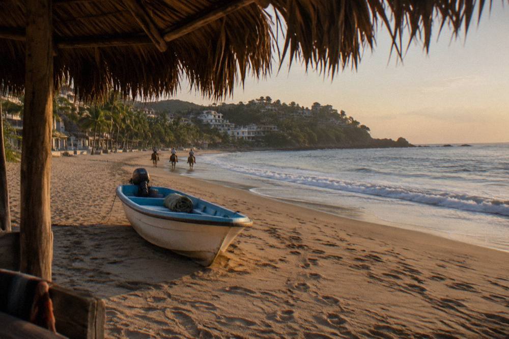 Small open tour boat resting on golden sand beside gentle waves at a beach town shoreline