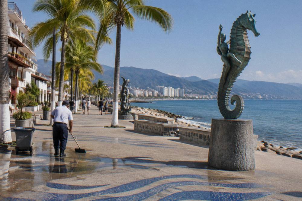 The Malecon boardwalk in Puerto Vallarta under a clear winter sky with sculptures along the waterfront