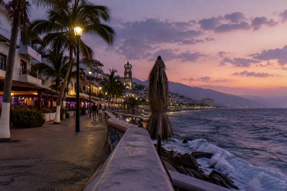 Sunset over Banderas Bay from the Puerto Vallarta shoreline with the Malecon lights beginning to glow