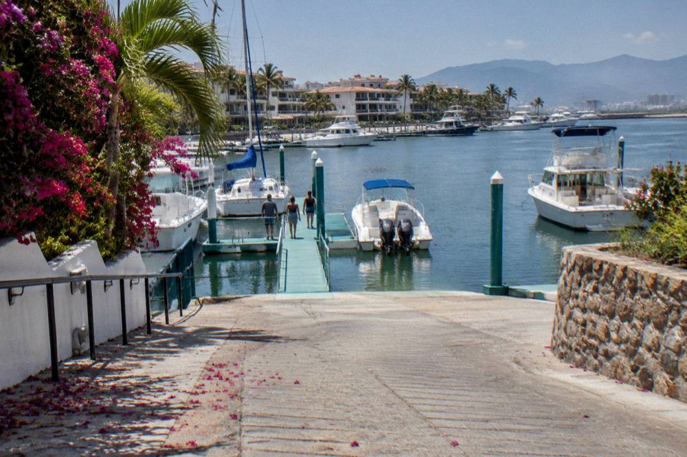 A pier with tour boats moored at a marina in Banderas Bay at midday